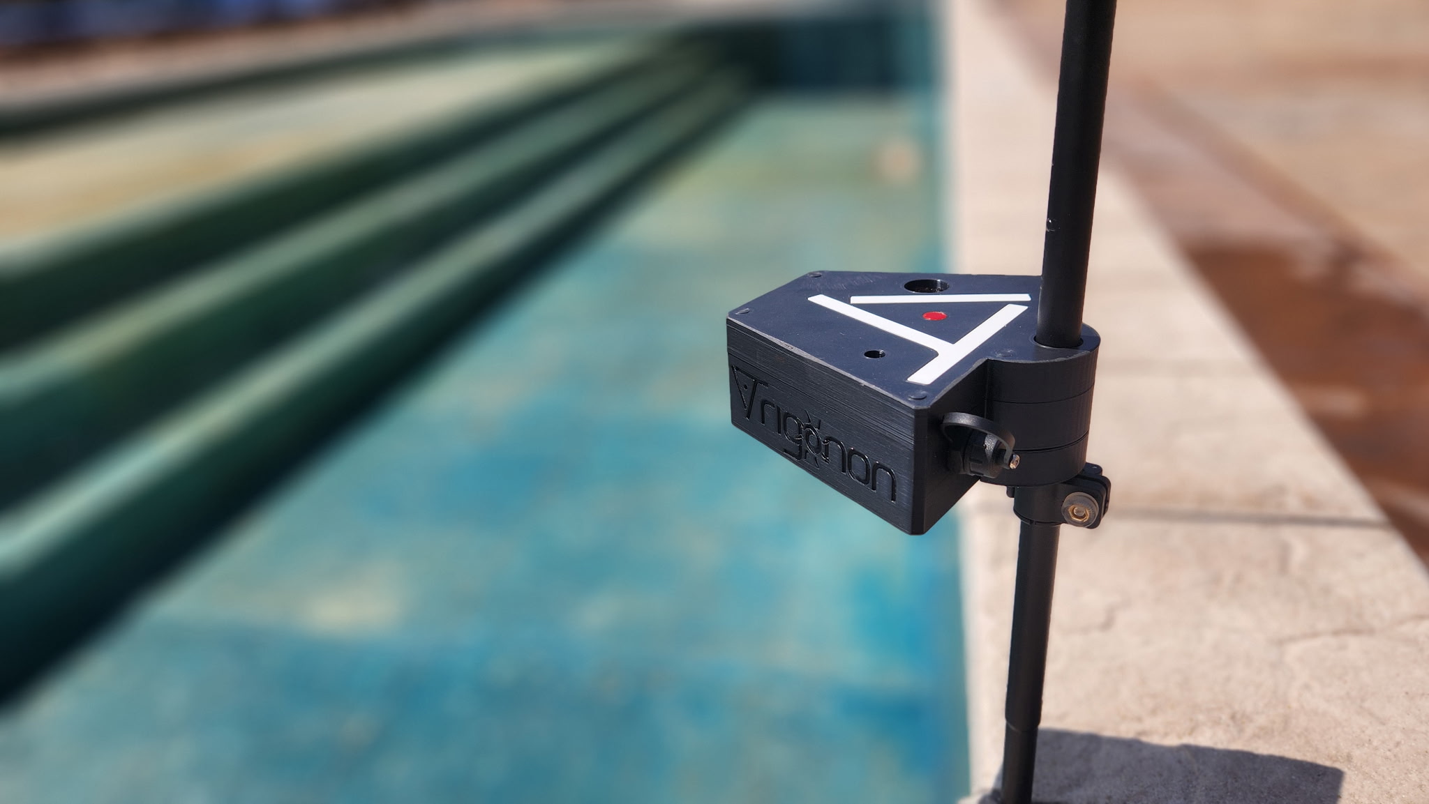 Trigonon Device with faded background Trigonon device close up shot with a swimming pool in the background
